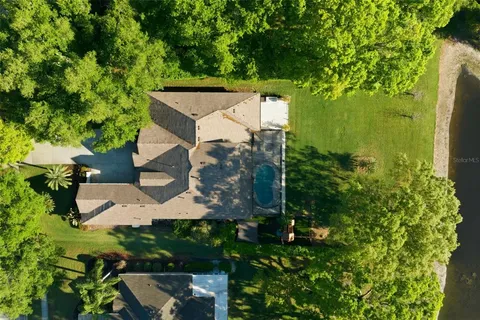 a view of a house with a big yard plants and large trees