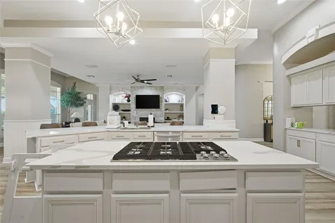 a kitchen with stainless steel appliances kitchen island granite countertop a dining table chairs and refrigerator