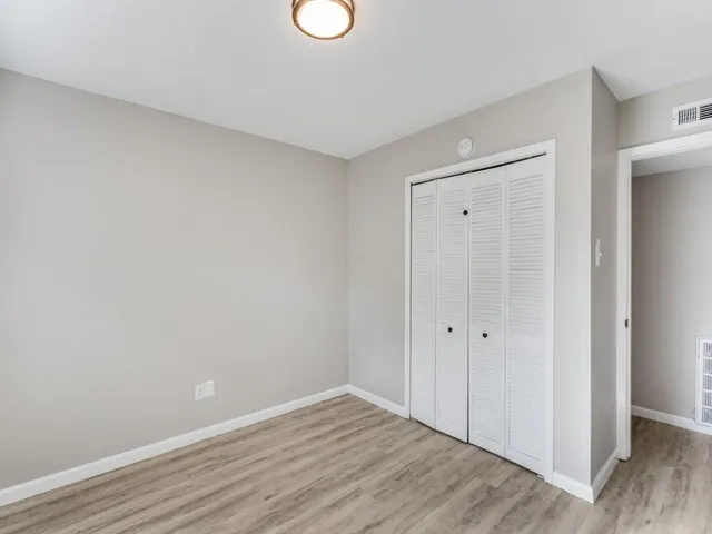 a view of an empty room with wooden floor