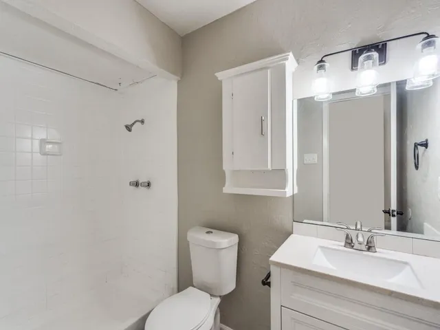 a bathroom with a toilet sink shower and mirror