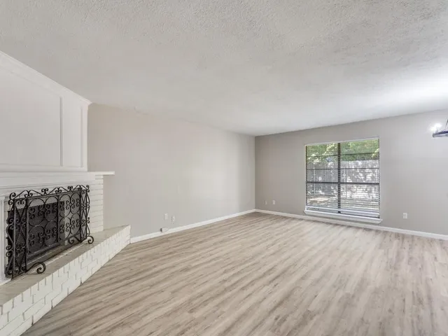 wooden floor fireplace and windows in an empty room