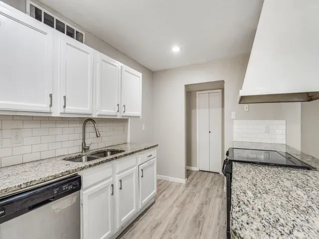 a kitchen with granite countertop a sink and cabinets