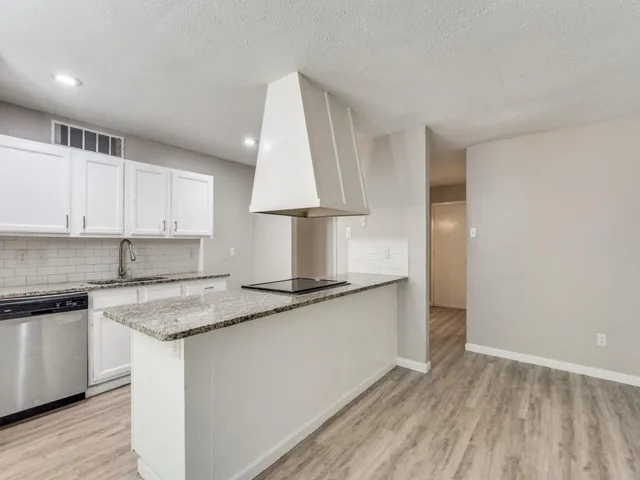 a kitchen with stainless steel appliances granite countertop a sink stove and cabinets
