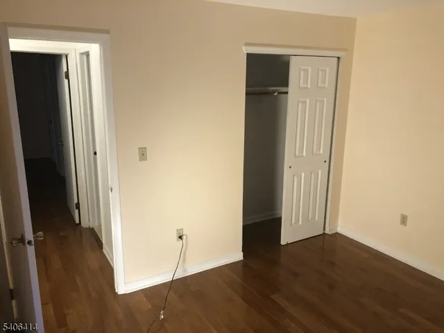 an empty room with wooden floor and closet