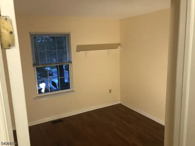a view of a small space with wooden floor and a window