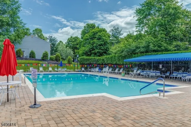 a view of a swimming pool with a patio and a yard