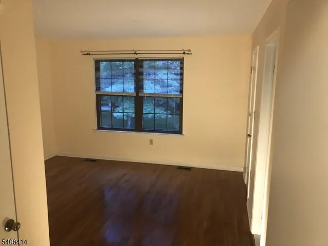 an empty room with wooden floor and a window