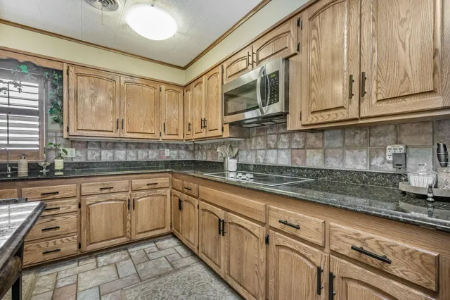 a large kitchen with granite countertop a large window