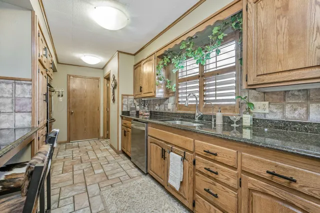 a kitchen with stainless steel appliances granite countertop a sink and cabinets