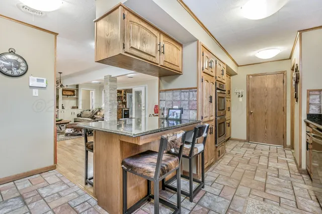 a kitchen with stainless steel appliances granite countertop a refrigerator and cabinets