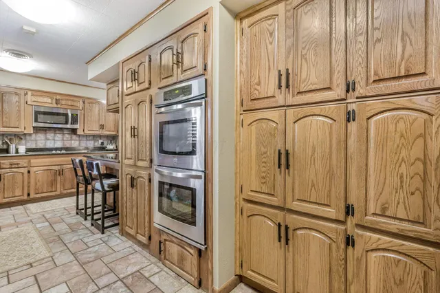 a kitchen with granite countertop cabinets stainless steel appliances and wooden cabinets