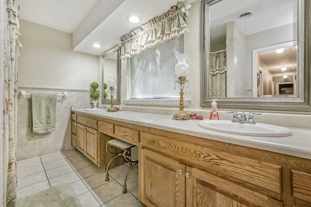 a bathroom with a granite countertop shower sink and mirror