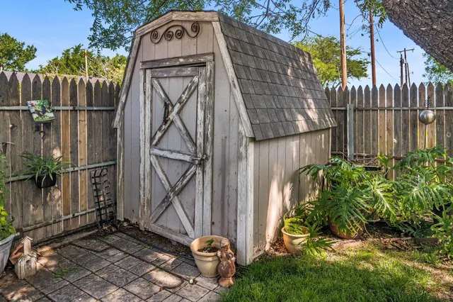 a backyard of a house with plants and wooden fence