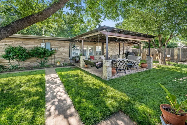 a view of a patio with table and chairs under an umbrella