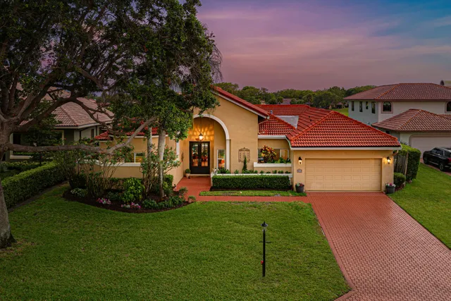 a front view of a house with a garden and deck