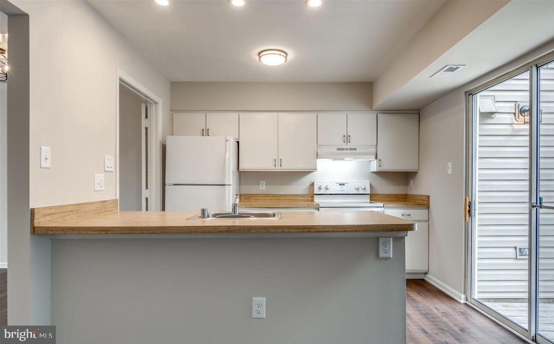 340 Lancaster Square Sterling, VA 20164 - Photo 2 of 12 a kitchen with kitchen island white cabinets and refrigerator
