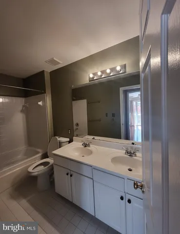 a spacious bathroom with a double vanity sink toilet and shower