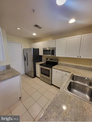 a kitchen that has a sink and a stove top oven