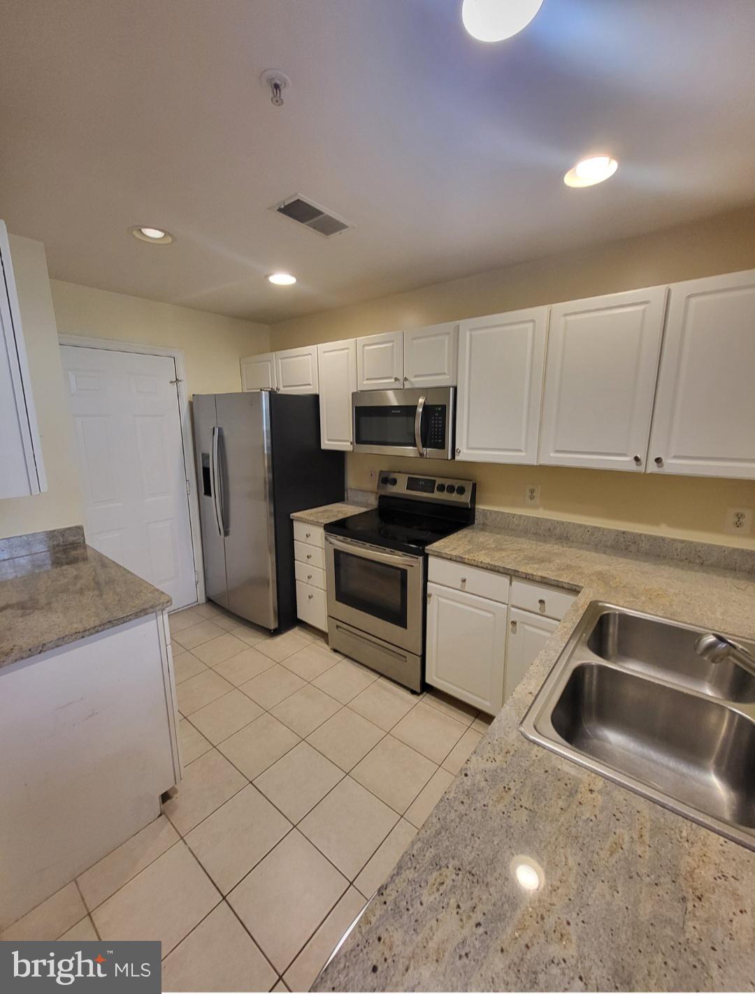 1970 Crescent Park Drive, Unit 19A Reston, VA 20190 - Photo 8 of 9 a kitchen that has a sink and a stove top oven