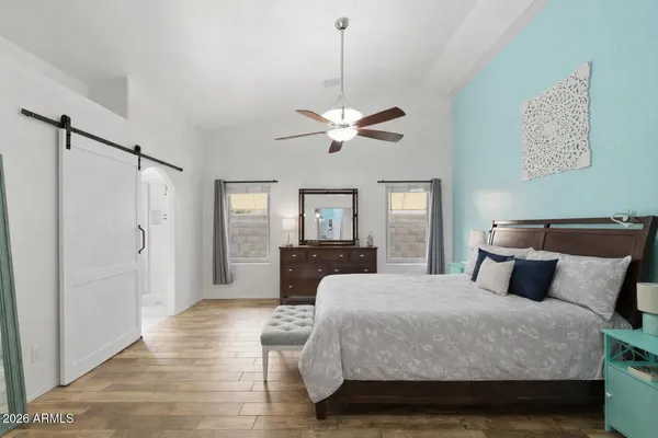 a bedroom with a large bed chandelier and a window