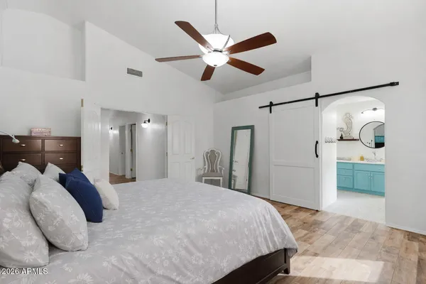 a bedroom with a large bed and a chandelier