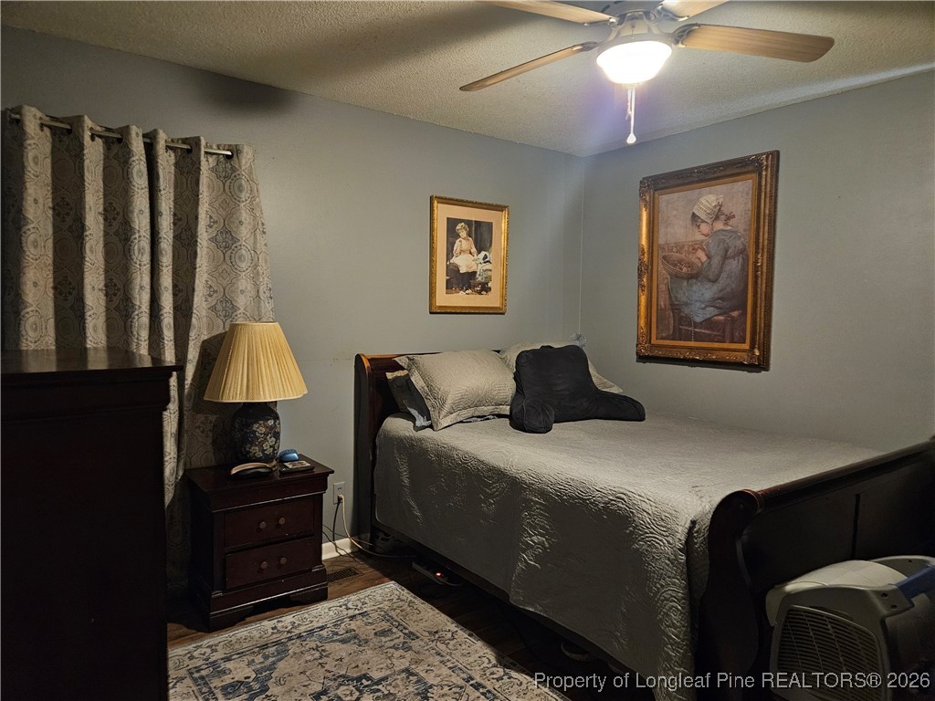 4547 Legion Road Hope Mills, NC 28348 - Photo 20 of 24 a bedroom with a bed and a chandelier