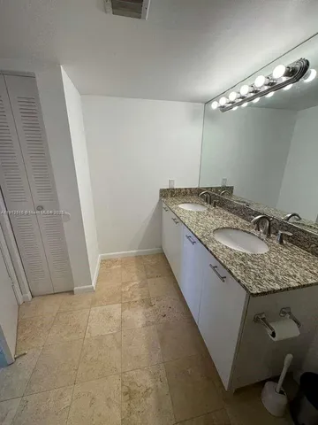a bathroom with a granite countertop sink a toilet a mirror and shower