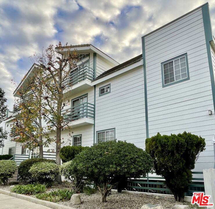 11738 Mayfield Avenue, Unit 114 Los Angeles, CA 90049 - Photo 2 of 25 a front view of a house with garden