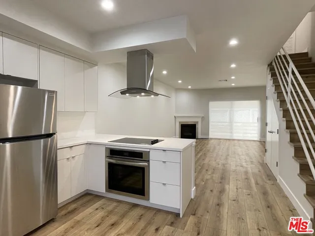 a kitchen with a stove a refrigerator and a fireplace