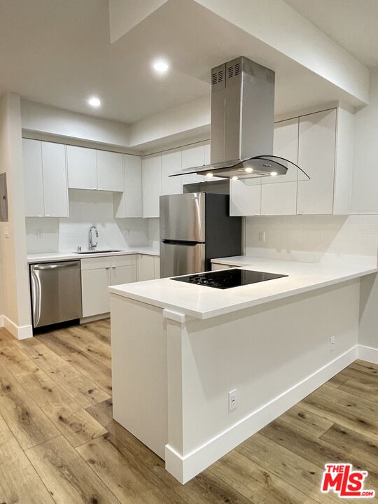 11738 Mayfield Avenue, Unit 114 Los Angeles, CA 90049 - Photo 7 of 25 a kitchen with kitchen island a stove a sink and a refrigerator