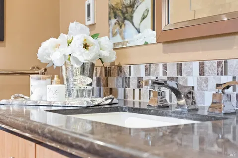 a bathroom with a granite countertop toilet sink and mirror