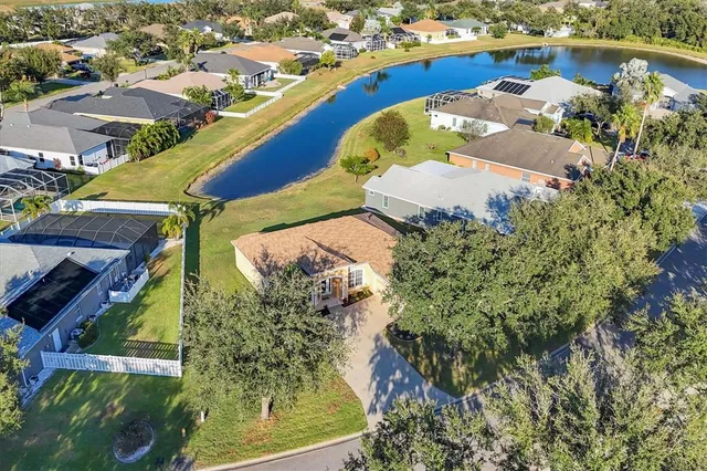 an aerial view of a house with a yard and lake view