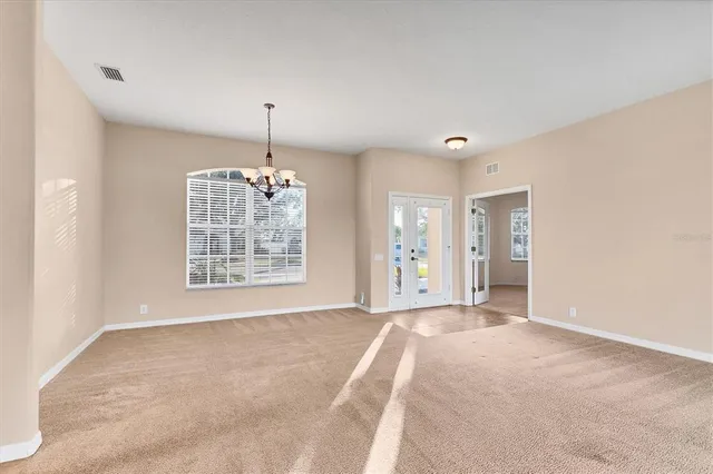 a view of an empty room with window and cabinet