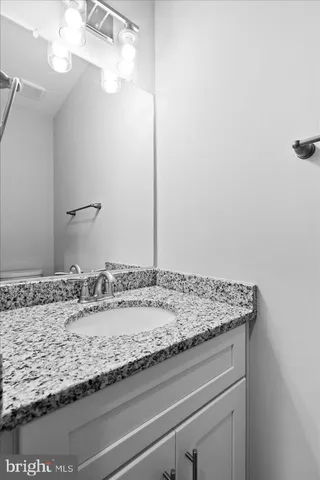 a bathroom with a granite countertop sink and a mirror