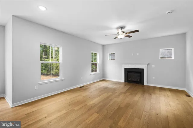 an empty room with windows and a fireplace