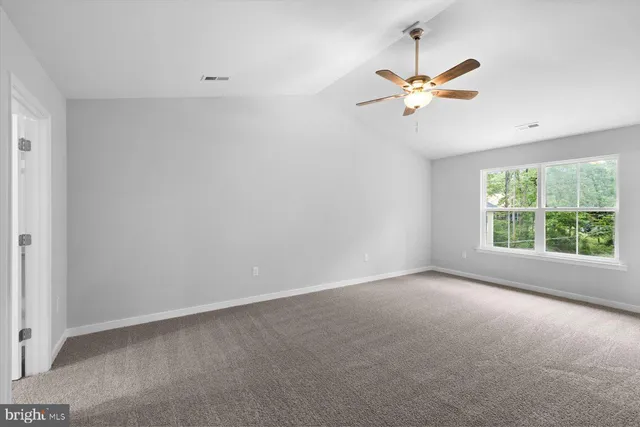 wooden floor in an empty room with a ceiling fan