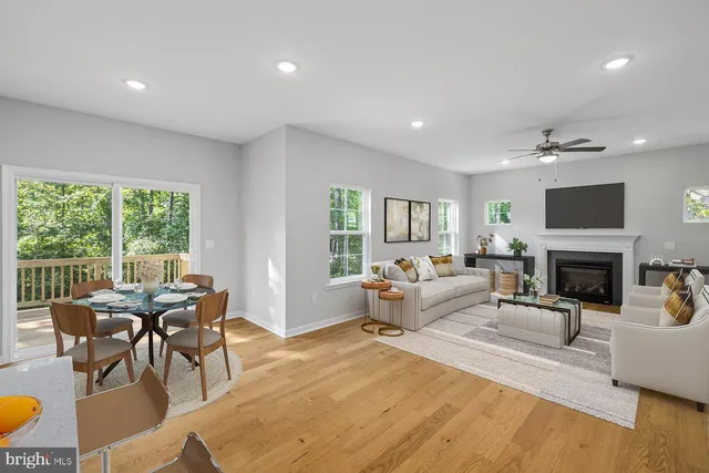 a living room with furniture a fireplace and a floor to ceiling window