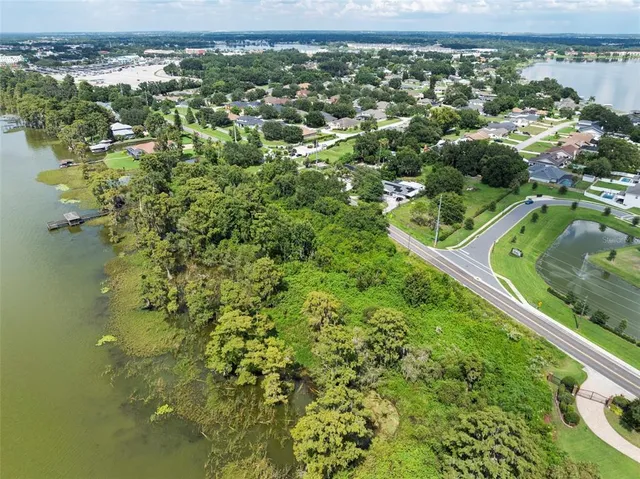 an aerial view of residential houses with outdoor space and trees