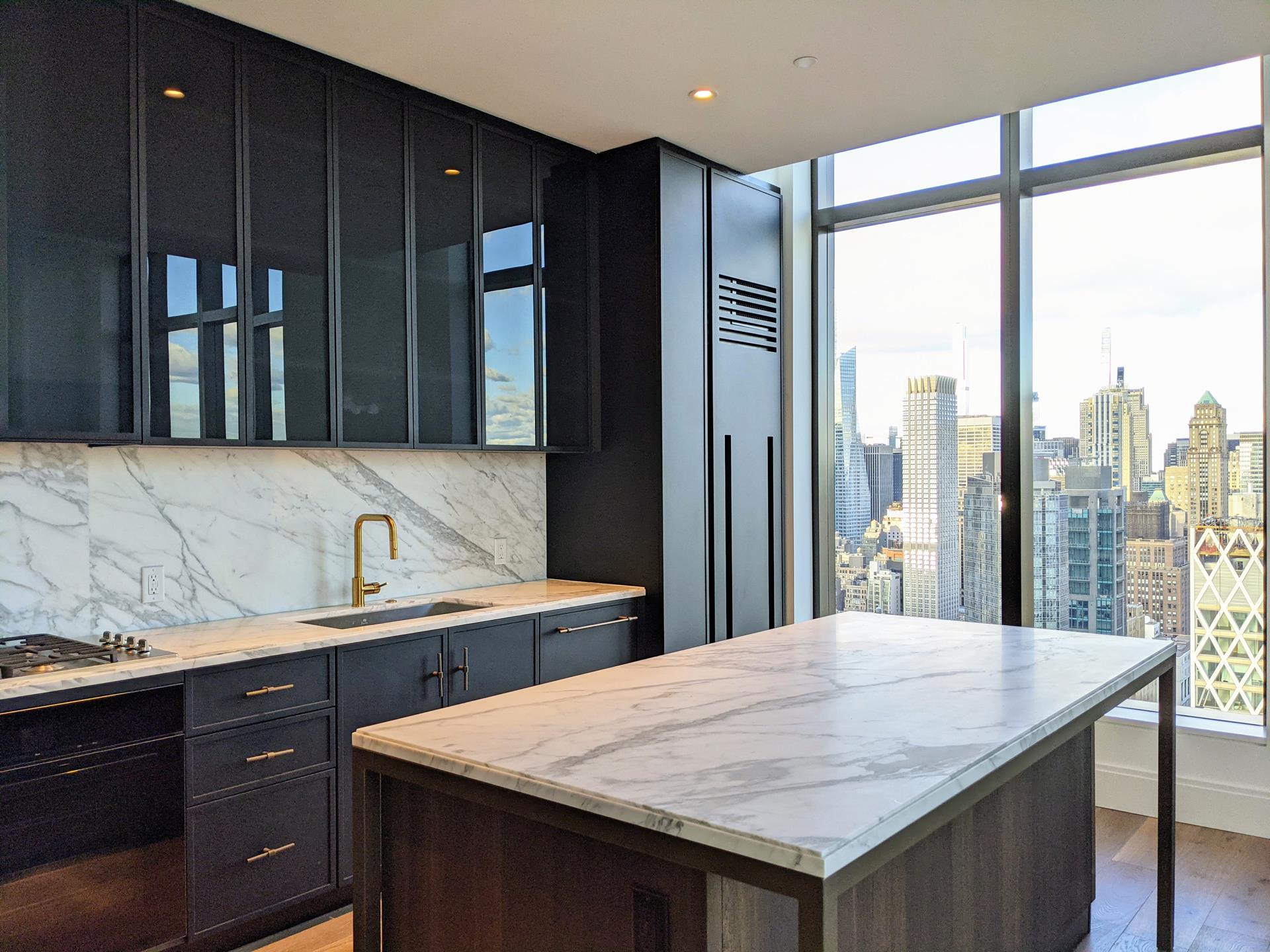 a kitchen with granite countertop a sink and a refrigerator