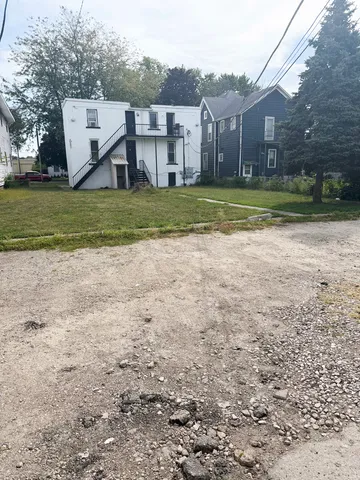 a view of a house with a yard and sitting area