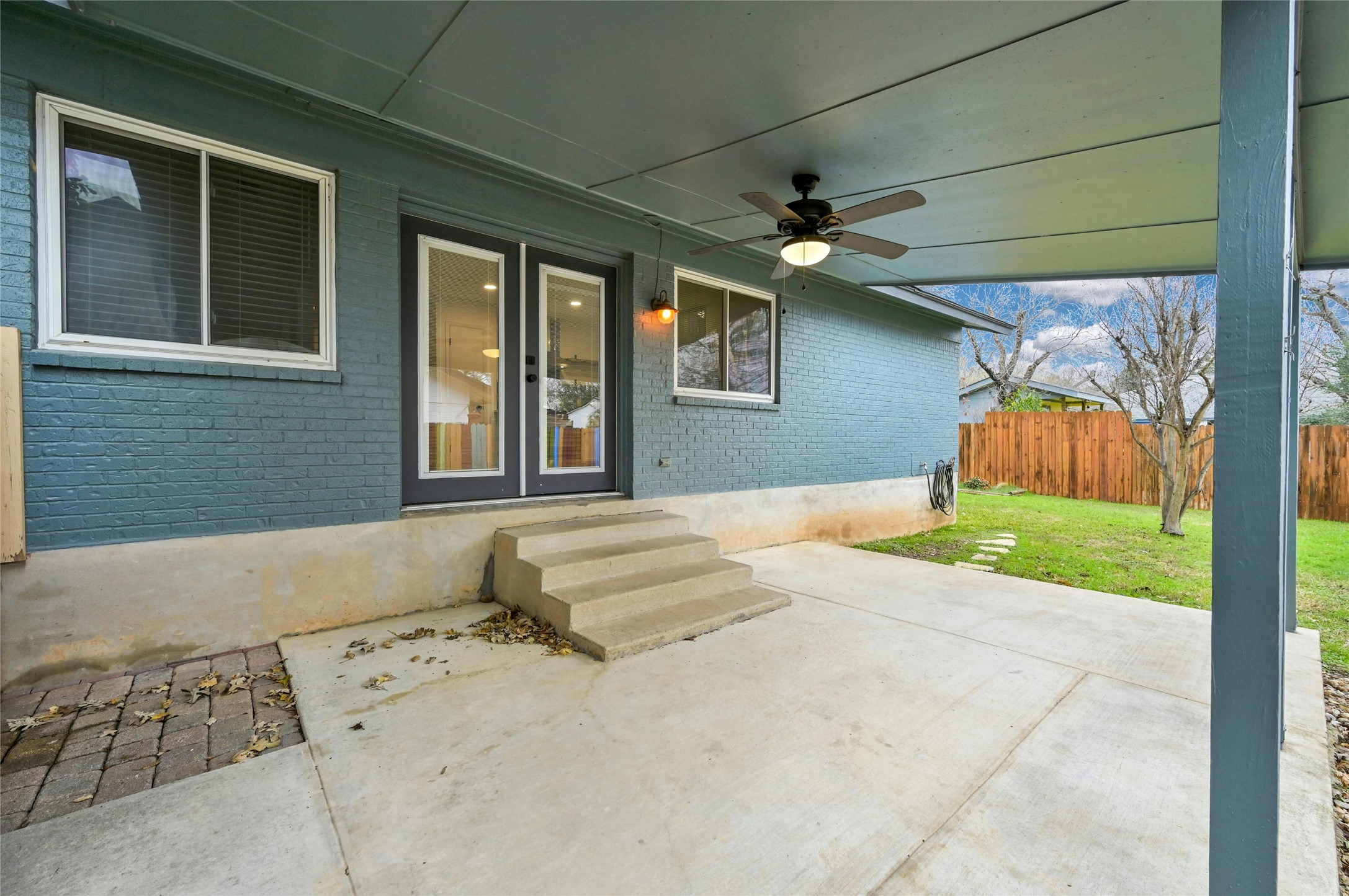4808 Wind River Road Austin, TX 78759 - Photo 18 of 21 Concrete steps lead down to a spacious covered patio overlooking the fenced backyard.