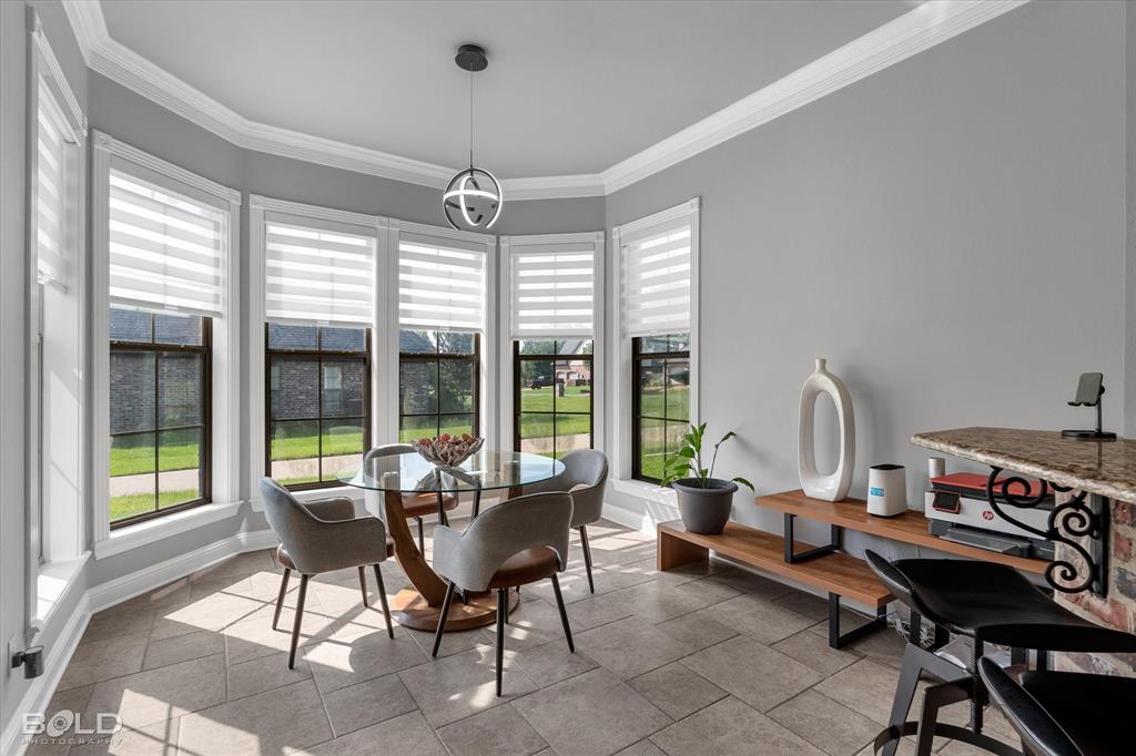 2220 Forest Hills Boulevard Haughton, LA 71037 - Photo 23 of 40 Bay window dining area featuring a contemporary pendant light fixture, extensive tile flooring, and a stone-topped bar with brick accent