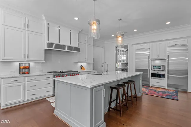 a kitchen with stainless steel appliances granite countertop a sink and a white cabinets