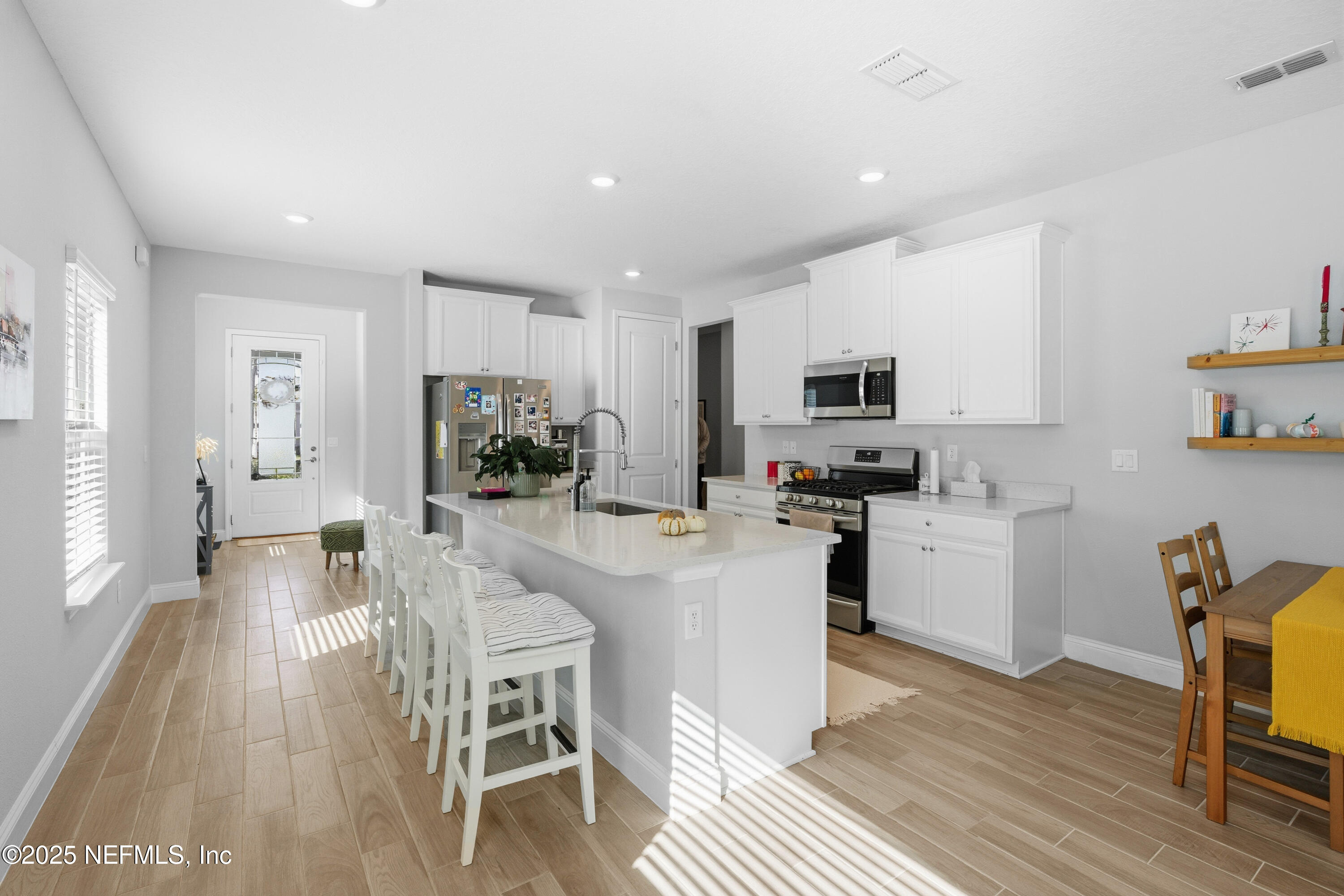 165 Killarney Avenue St. Johns, FL 32259 - Photo 11 of 63 a kitchen with stainless steel appliances granite countertop a stove top oven a sink a dining table and chairs with wooden floor