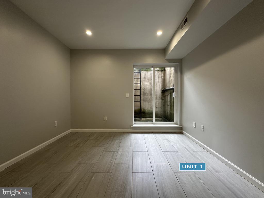 1606 Point Breeze Avenue Philadelphia, PA 19145 - Photo 15 of 35 an empty room with wooden floor and windows