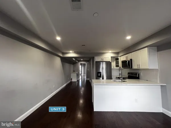 a view of kitchen with microwave and refrigerator