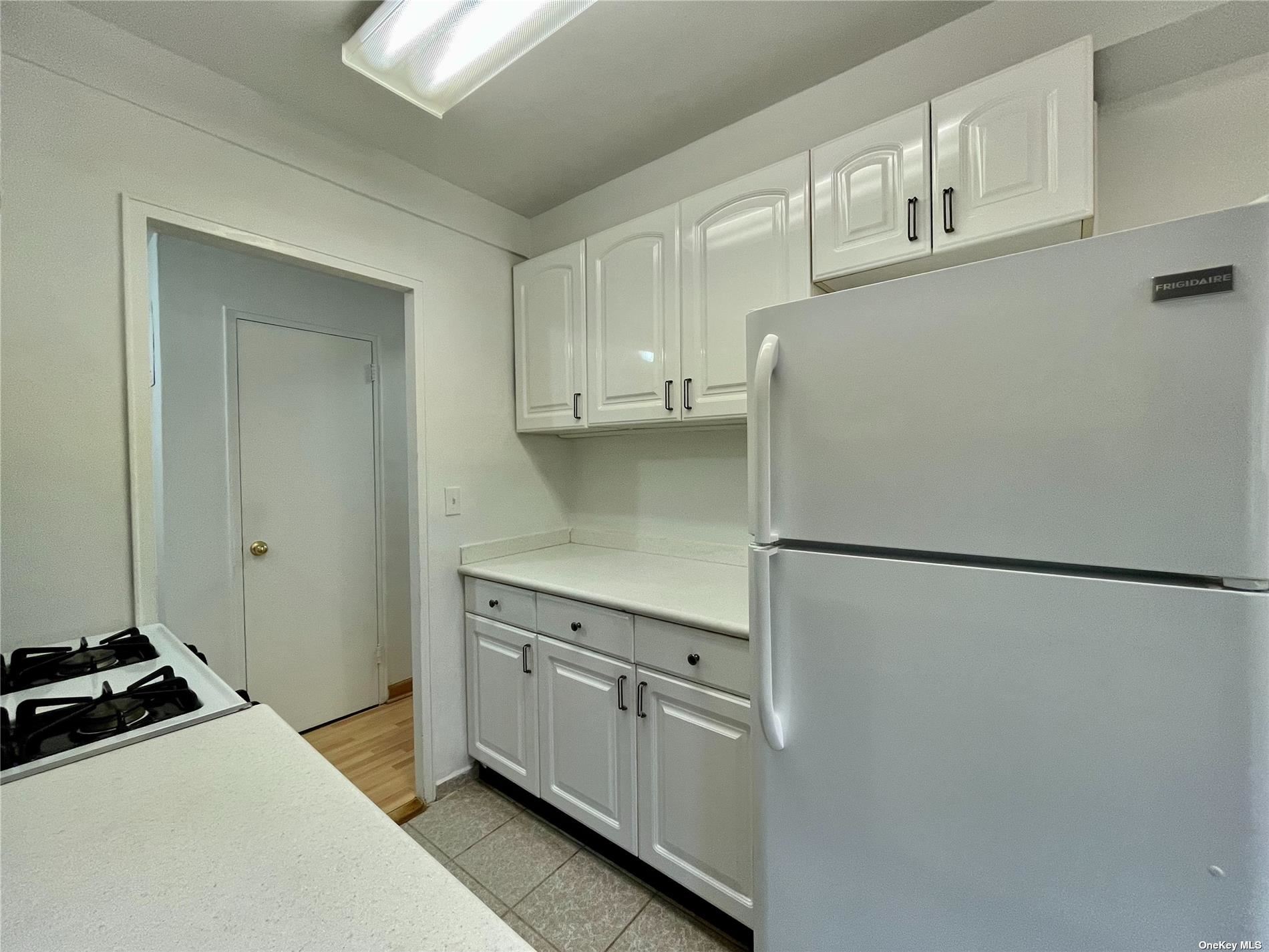 a kitchen with cabinets and a refrigerator
