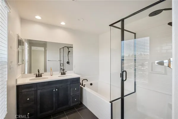 a spacious bathroom with a double vanity sink a mirror and shower