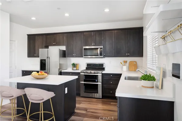 a kitchen with a sink a stove and chairs