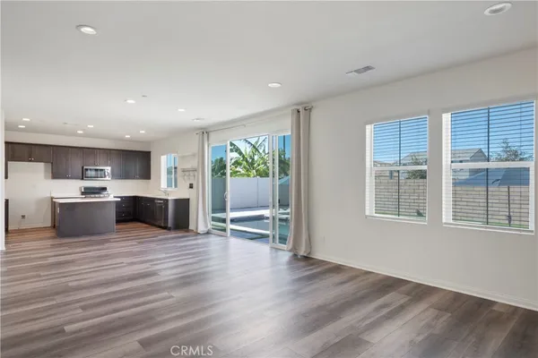 a large kitchen with stainless steel appliances granite countertop a large cabinets and a wooden floor